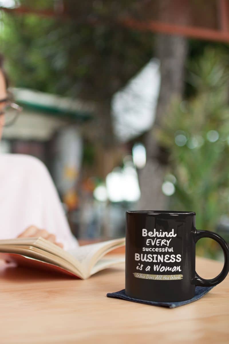 Motivational mugs with a girl reading a book on the table and a cup of coffee next to her