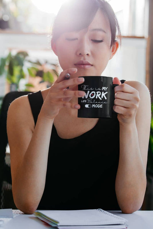 Motivational work life balance mug with a girl working with a cup of coffee and a pen in her hand with a thoughtful look on her face
