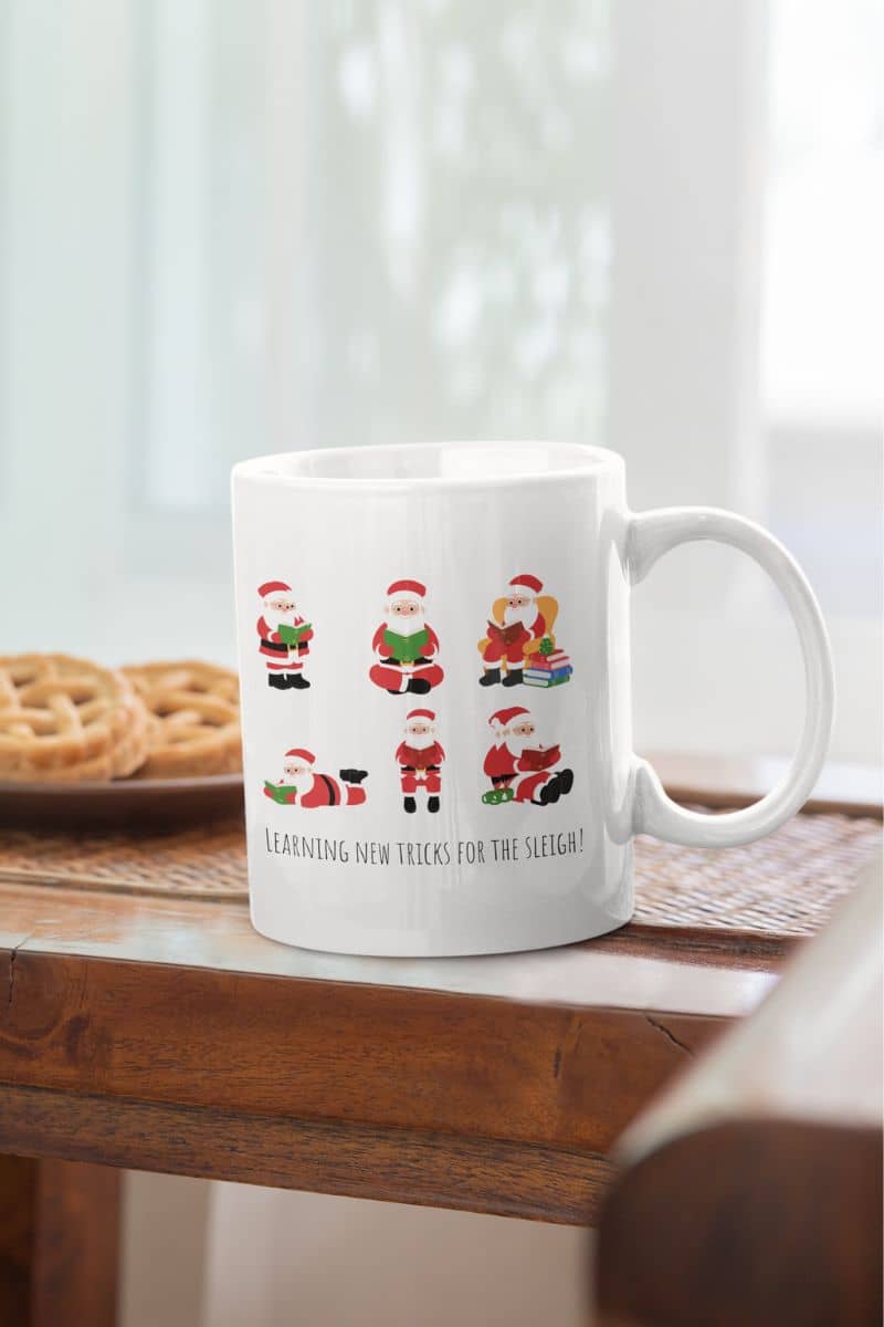 Mug 11oz Learning New Tricks For The Sleigh with a glass of water and a plate of cookies on the table