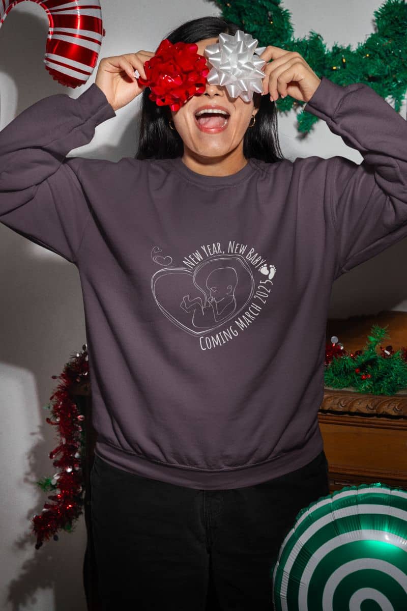 New year, new baby sweatshirt with the girl using 2 bows to cover her eyes