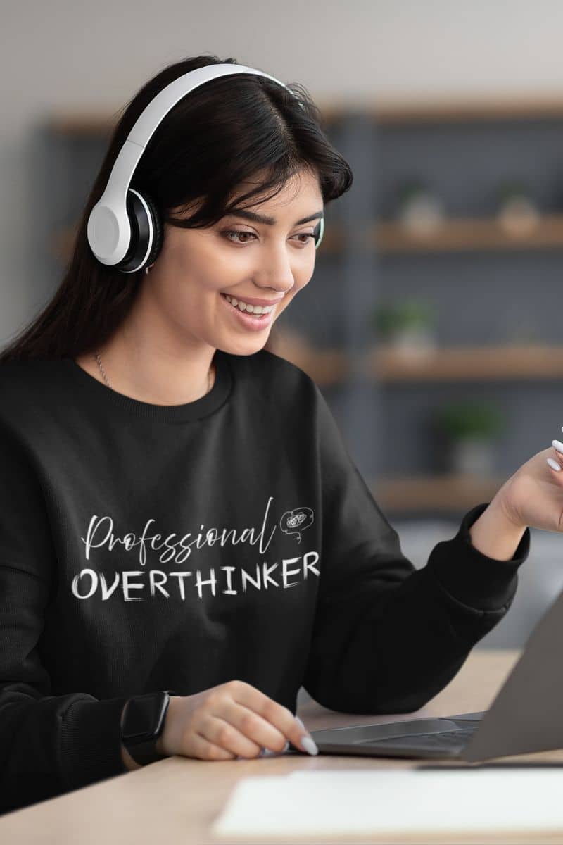 Overthinking sweatshirt with the girl wearing headphones and looking at the laptop with a bright smile