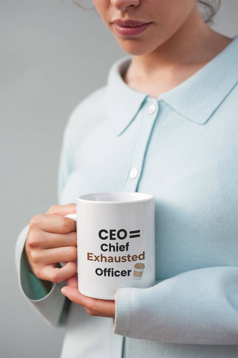 Overworked boss gift with a person holding a mug with text 'CEO = Chief Exhausted Officer', wearing a light blue shirt.