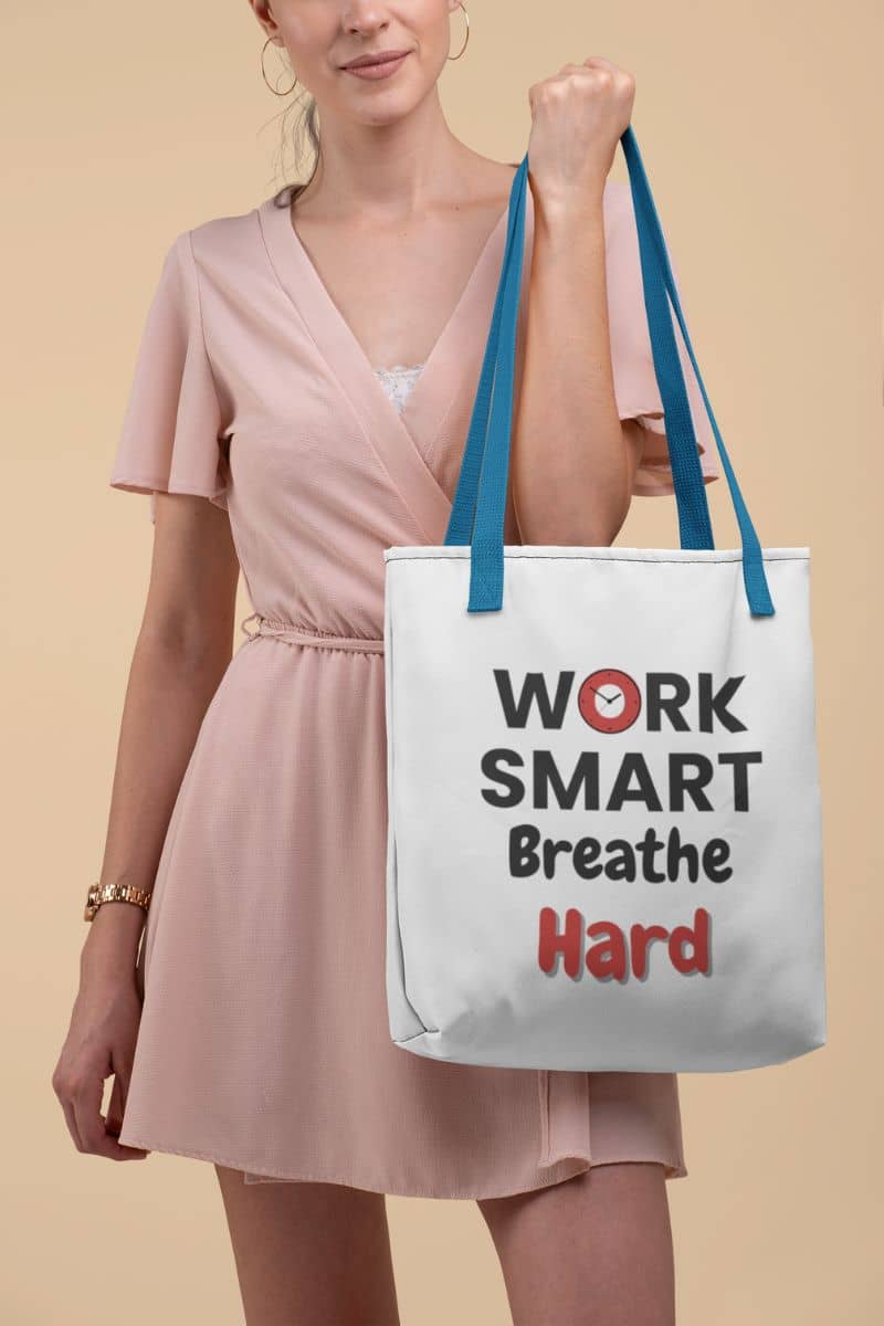 Productivity quote tote with a woman holding a tote bag with 'Work Smart Breathe Hard' text on a beige background