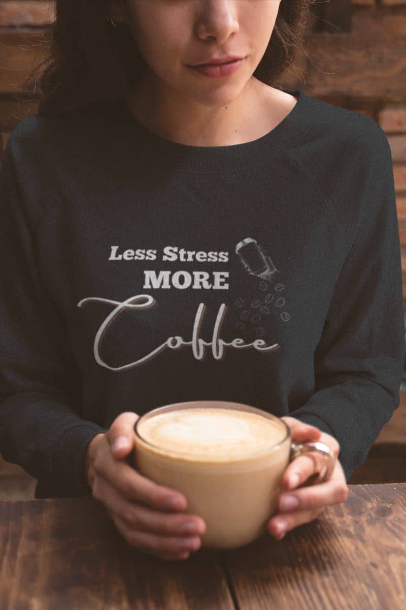Relaxed coffee sweatshirt with a girl using both hands to support a cup of coffee on the table