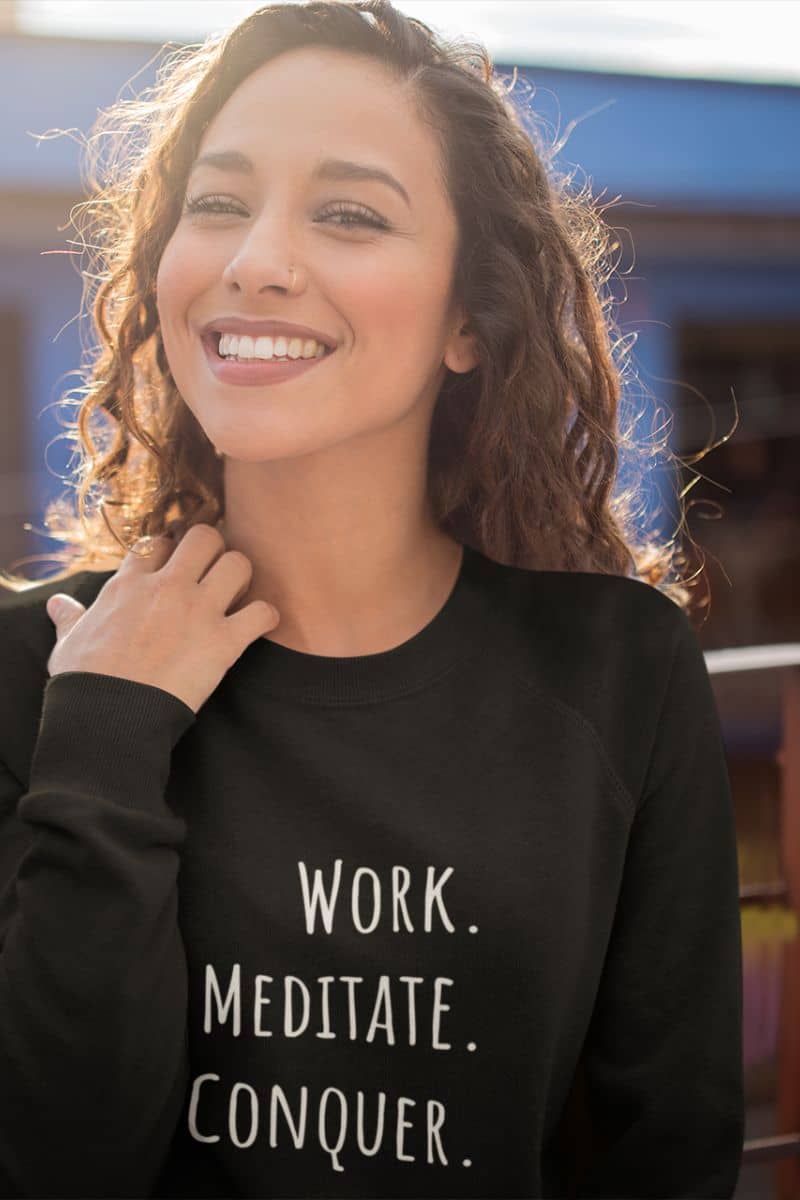 Relaxed fit meditation sweatshirt with a girl smiling brightly and posing