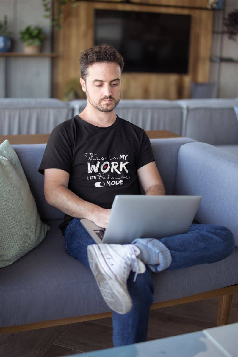 Relaxed work-life balance t-shirt with a man working on a laptop on the sofa