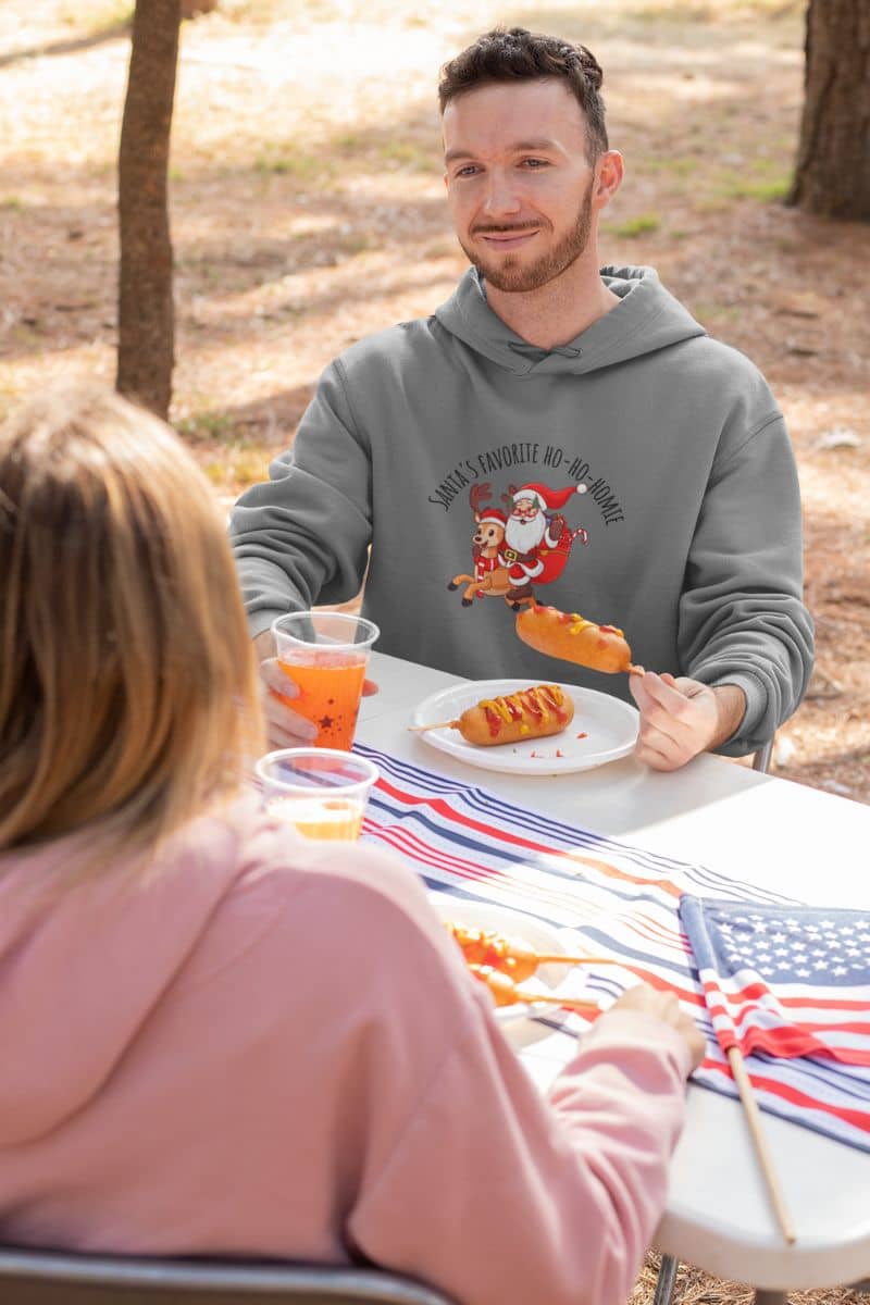 Cozy Christmas Hoodie with a boy and a girl talking at an outdoor party with fast food and drinks