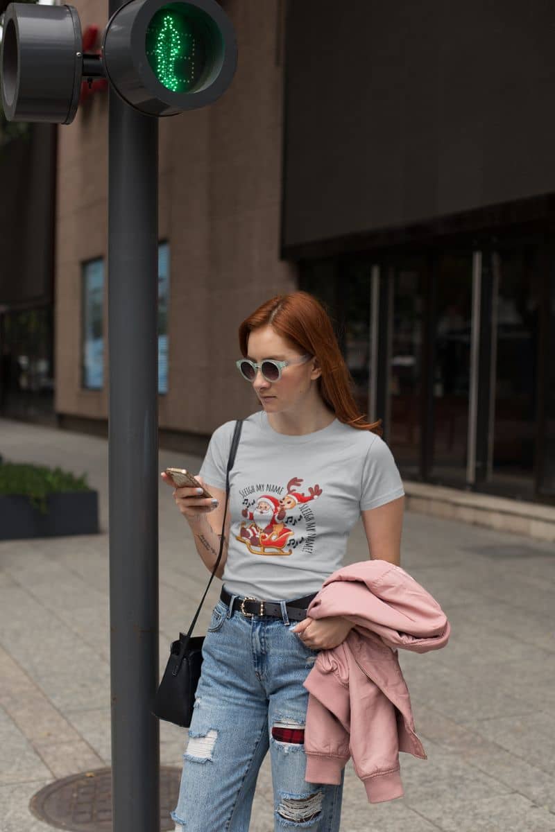 Sleigh My Name, Sleigh My Name T-Shirt. A girl is reading a text message while waiting at a traffic light.