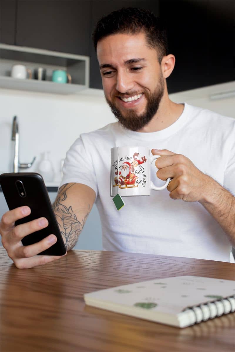 Sleigh my name, sleigh my name festive christmas mug with a man looking at his phone and holding a cup of hot tea