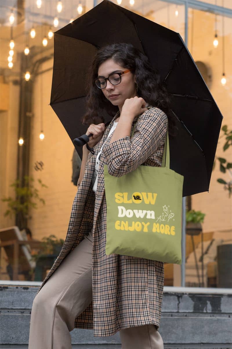 Slow living tote bag with a woman carrying an umbrella on a rainy day