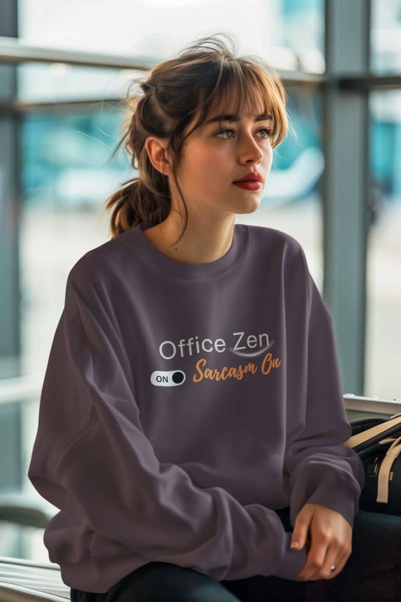 Soft and cozy sweatshirt with a woman wearing a purple sweatshirt with text, sitting in an airport.