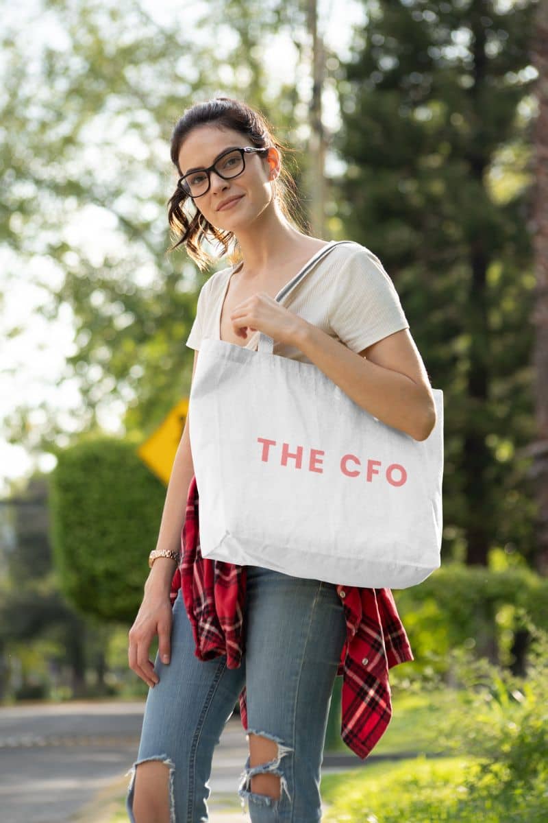 Stylish canvas tote bag with a woman holding a tote bag with 'THE CFO' text outdoors