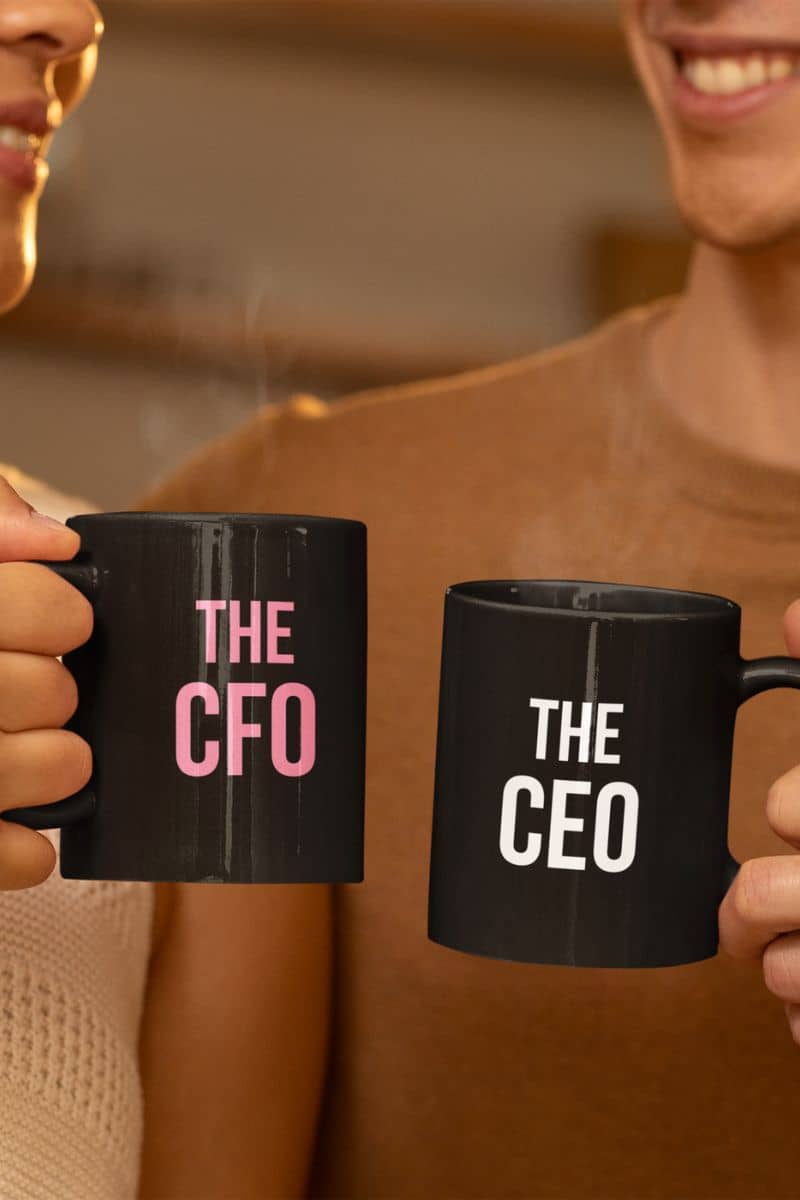 The CEO ceramic coffee mug with two people holding black mugs with 'THE CFO' and 'THE CEO' text.