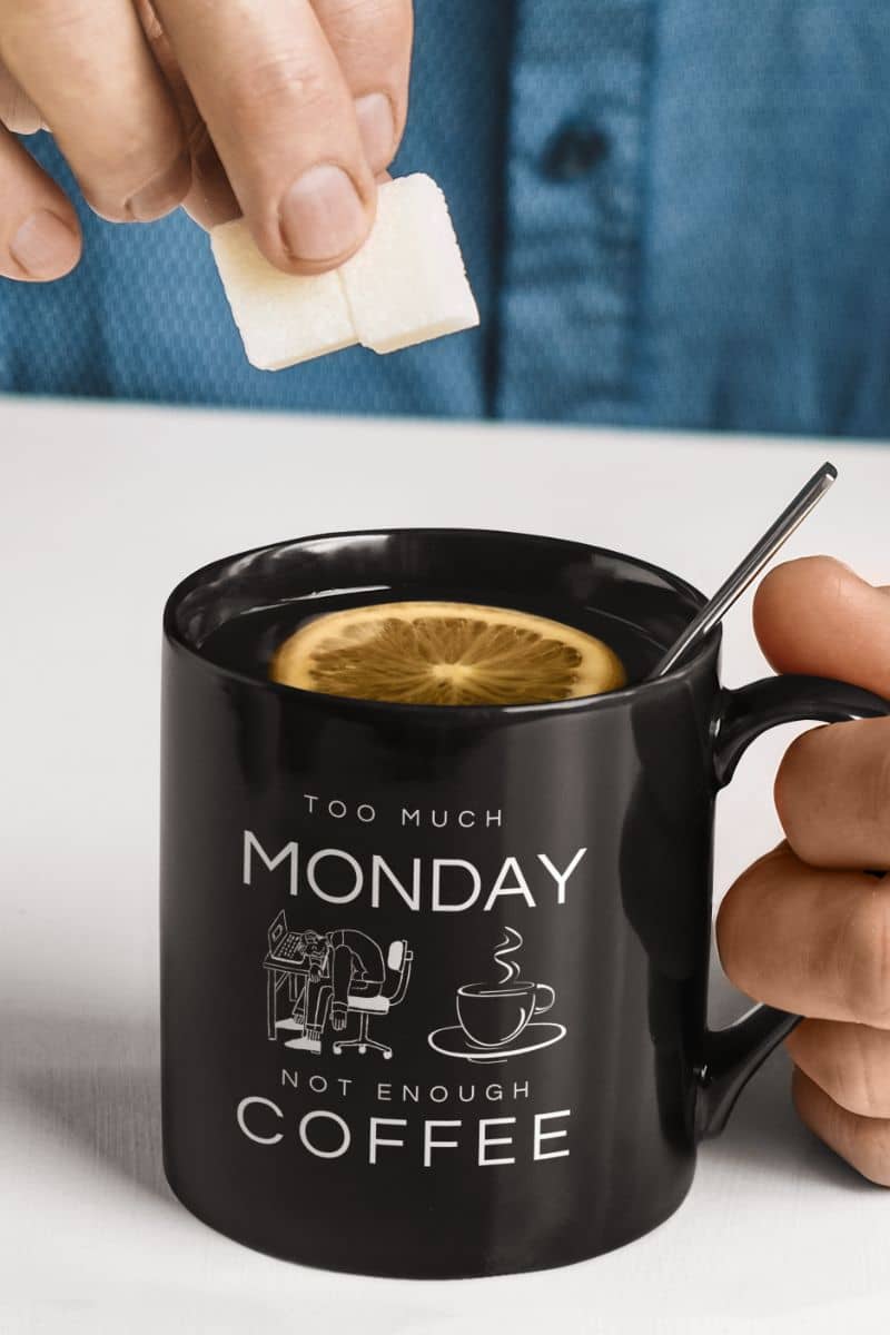 Too much monday mug with a man preparing to put sugar cubes in his cup of tea