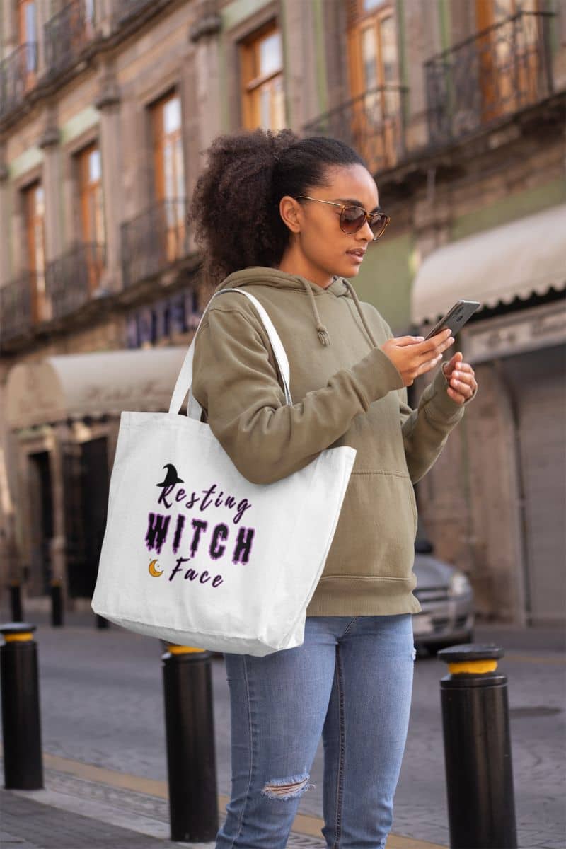 Witch humor tote with woman holding a phone and a tote bag with text in an urban setting
