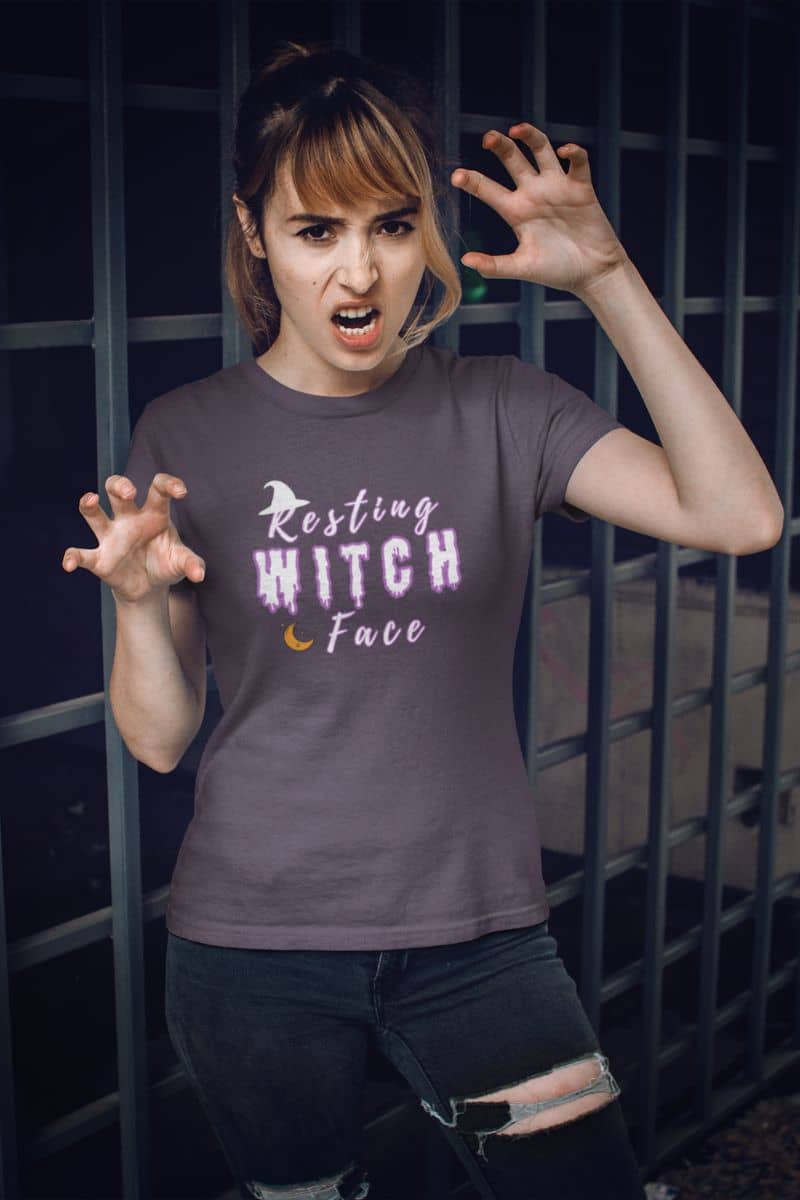 Witches be crazy shirt with a person wearing a t-shirt with 'Resting Witch Face' text in front of a dark background.