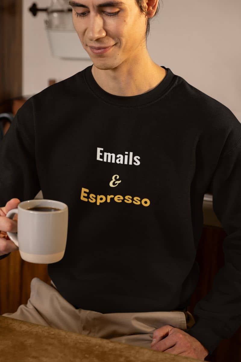 Work from home sweater with a person wearing a black sweatshirt with 'Emails & Espresso' text, holding a white mug.