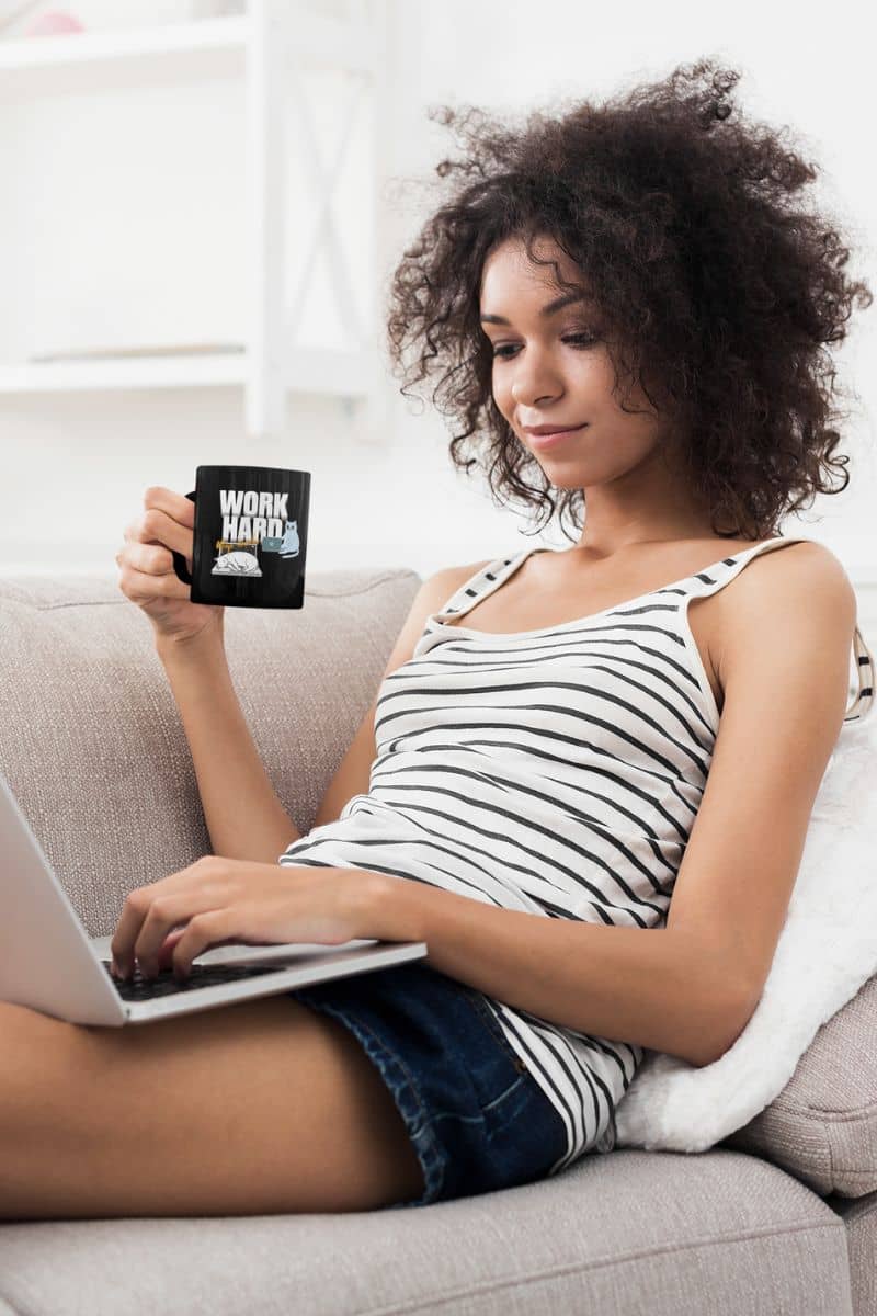 Work hard, nap harder mug with a girl sitting on the sofa working and holding a cup of coffee