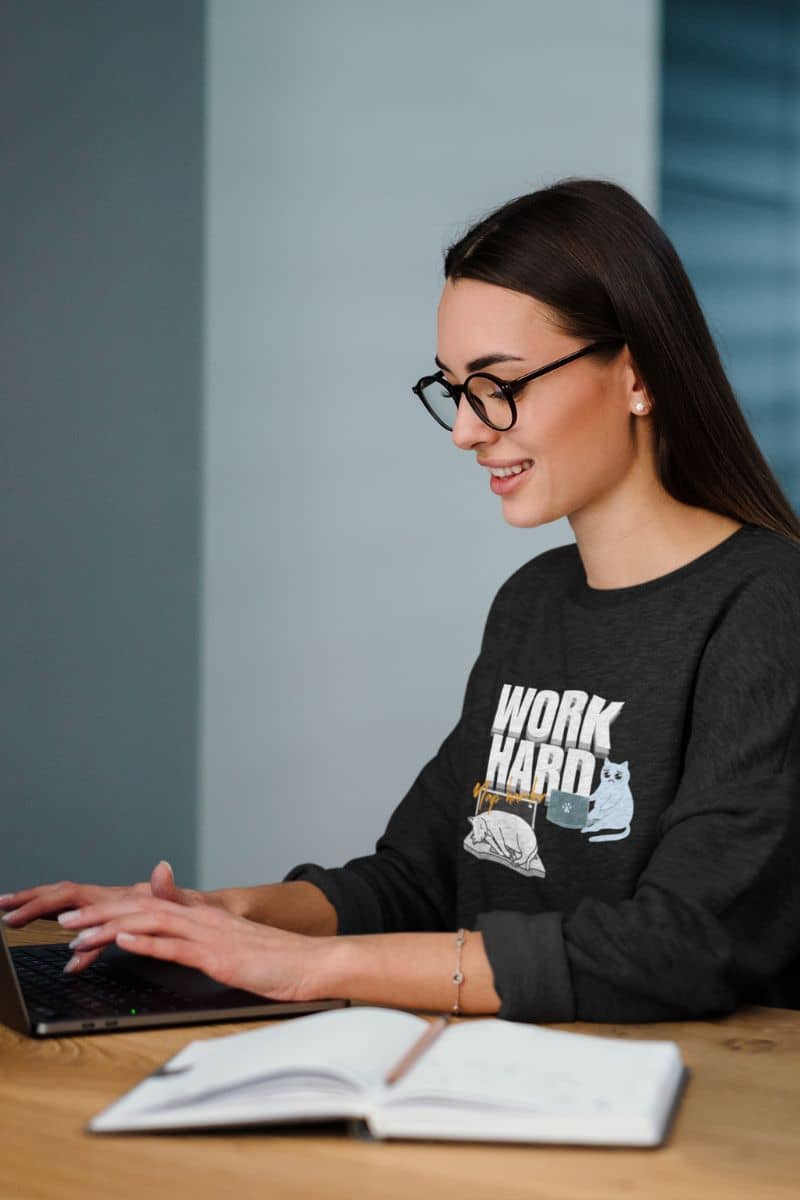 Work hard, nap harder sweatshirt with a girl working on a laptop
