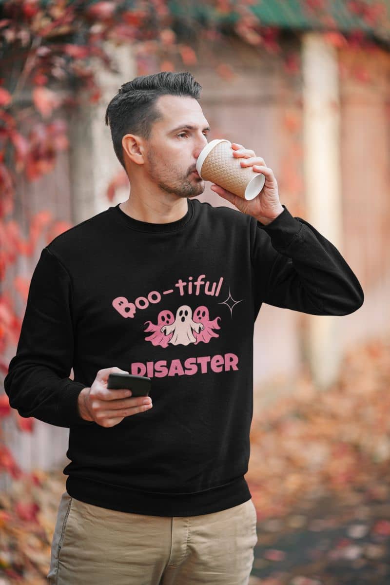 boo crew pullover with a man wearing a black sweatshirt with a humorous design, drinking from a paper cup.