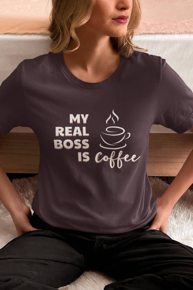 coffee addict tee with a person wearing a dark t-shirt with 'My Real Boss is Coffee' text and graphic.