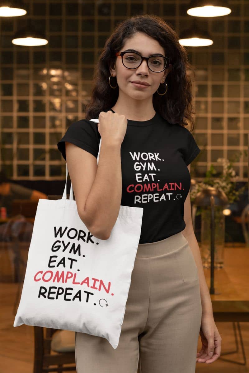 everyday carryall bag with a woman wearing a black t-shirt and holding a tote bag with motivational phrases.
