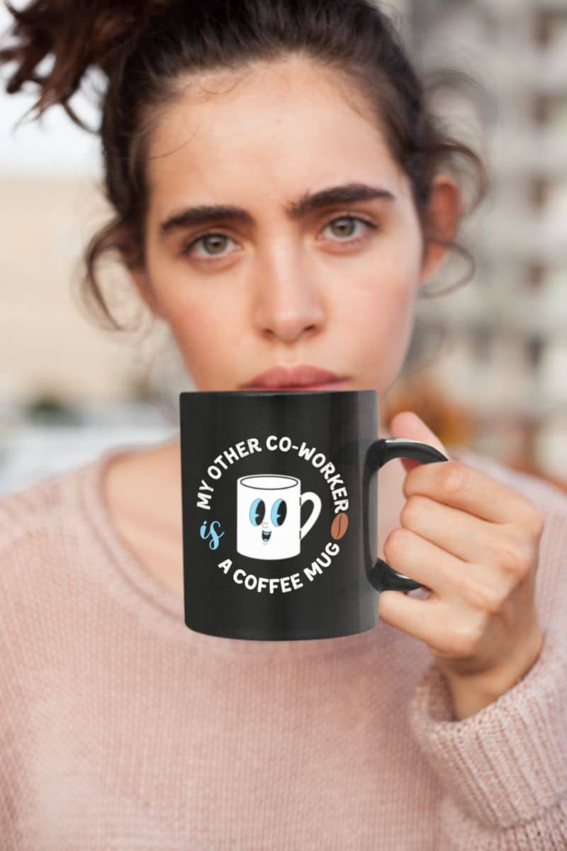 funny coworker coffee mugs with a person holding a black mug with a humorous design and text.