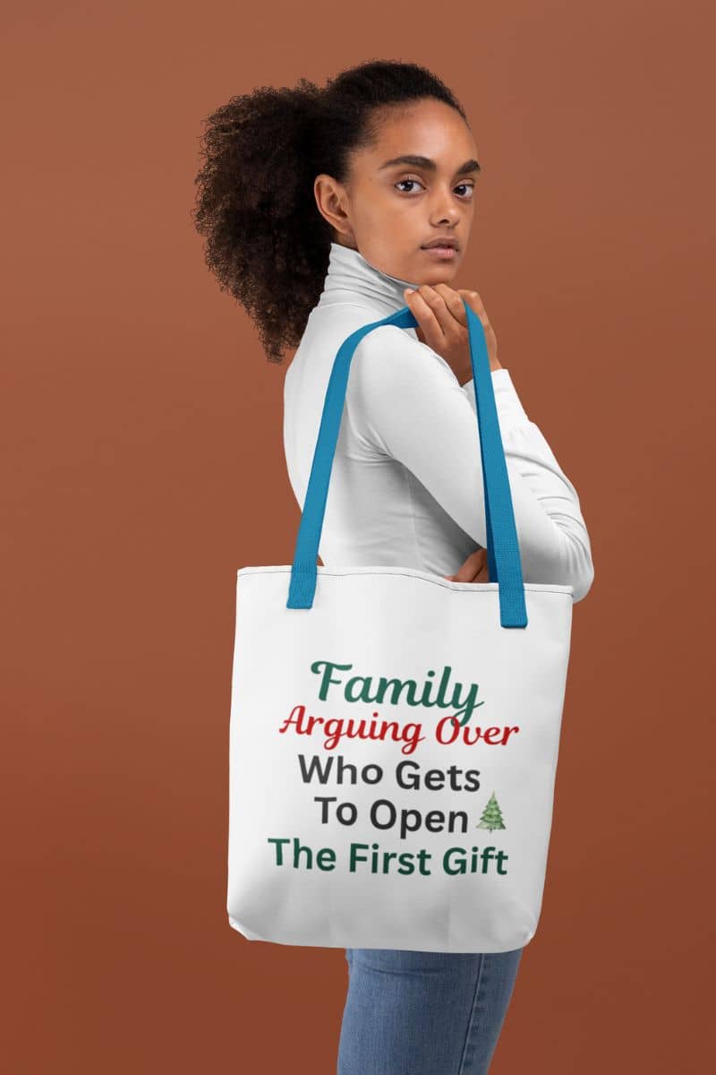 funny holiday gift bag with a person holding a tote bag with humorous text 'Family: Arguing Over Who Gets To Open The First Gift' on a brown background