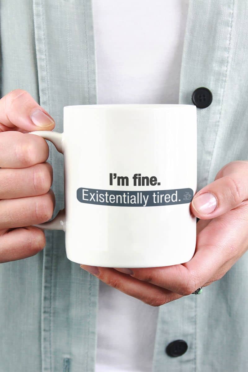funny mug with a person holding a mug with text 'I'm fine. Existentially tired.'