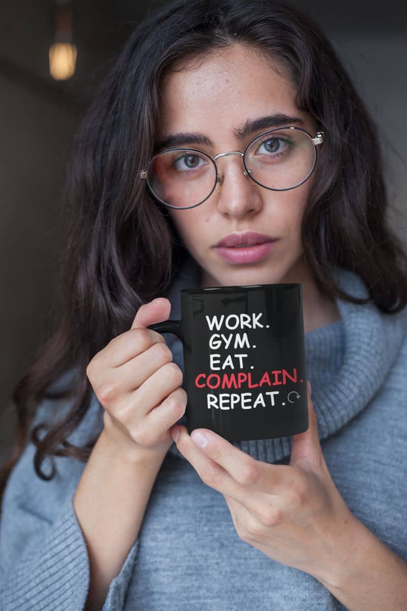 morning sarcasm cup with a girl holding a black mug with text 'Work. Gym. Eat. Complain. Repeat'
