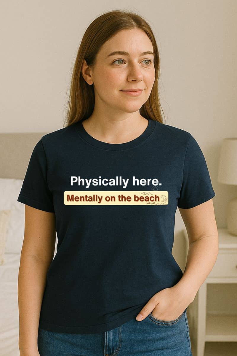 ocean vibes t-shirt with a person wearing a navy blue t-shirt with text 'Physically here. Mentally on the beach'