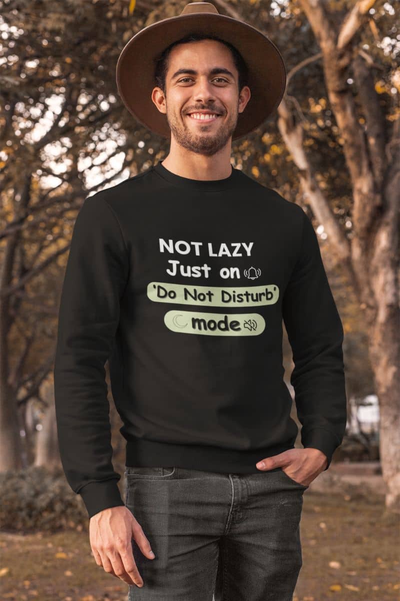 quiet mode hoodie with a man wearing a black sweatshirt with text 'NOT LAZY, Just on 'Do Not Disturb' mode' outdoors