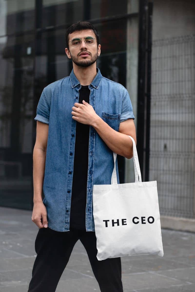 reusable minimalist tote with a man holding a tote bag with 'THE CEO' text in an urban setting