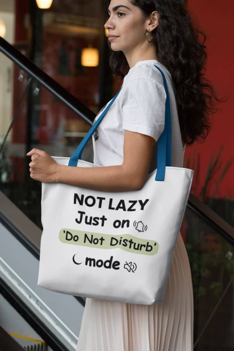 sarcastic quote canvas bag with a woman holding a tote bag with humorous text 'NOT LAZY, Just on 'Do Not Disturb' mode'.