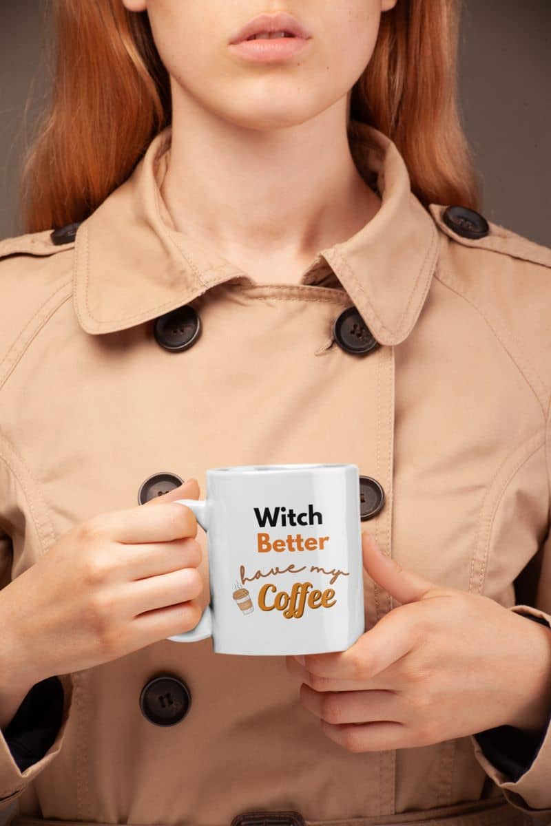 spooky caffeine mug with a person holding a mug with text wearing a beige coat