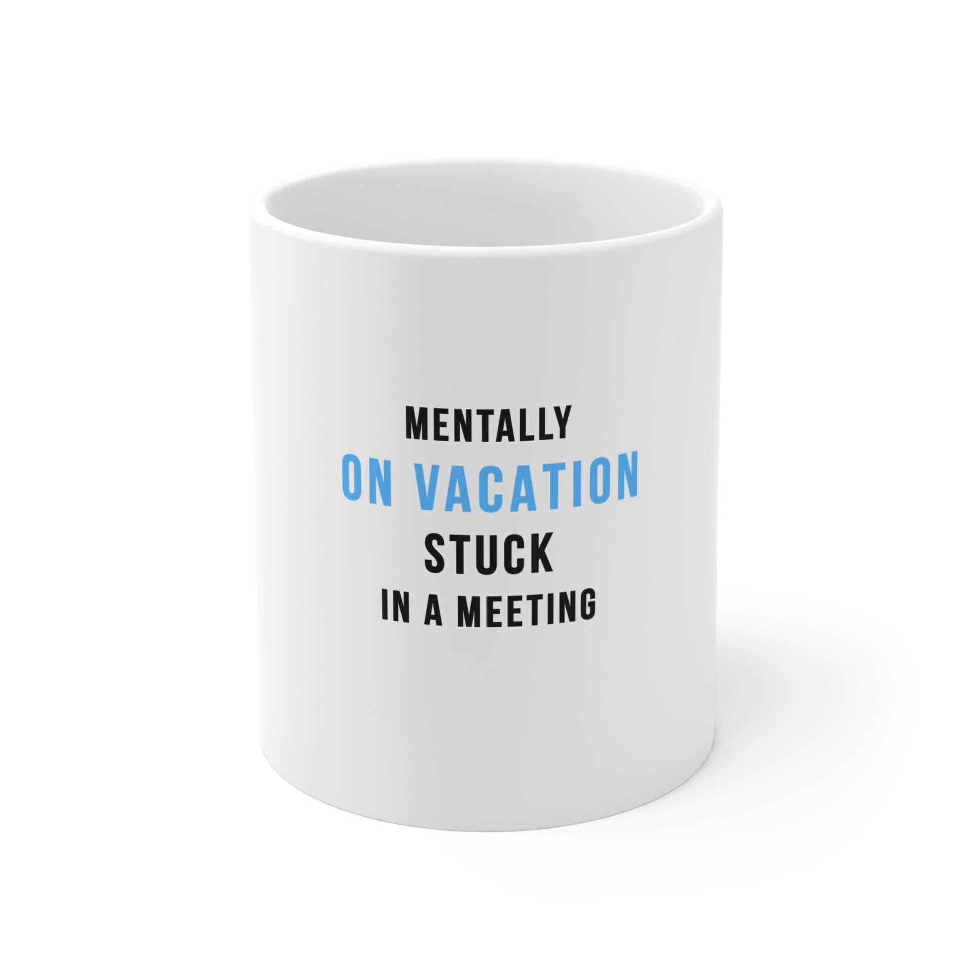 White mug with text 'Mentally on vacation, stuck in a meeting' on a white background