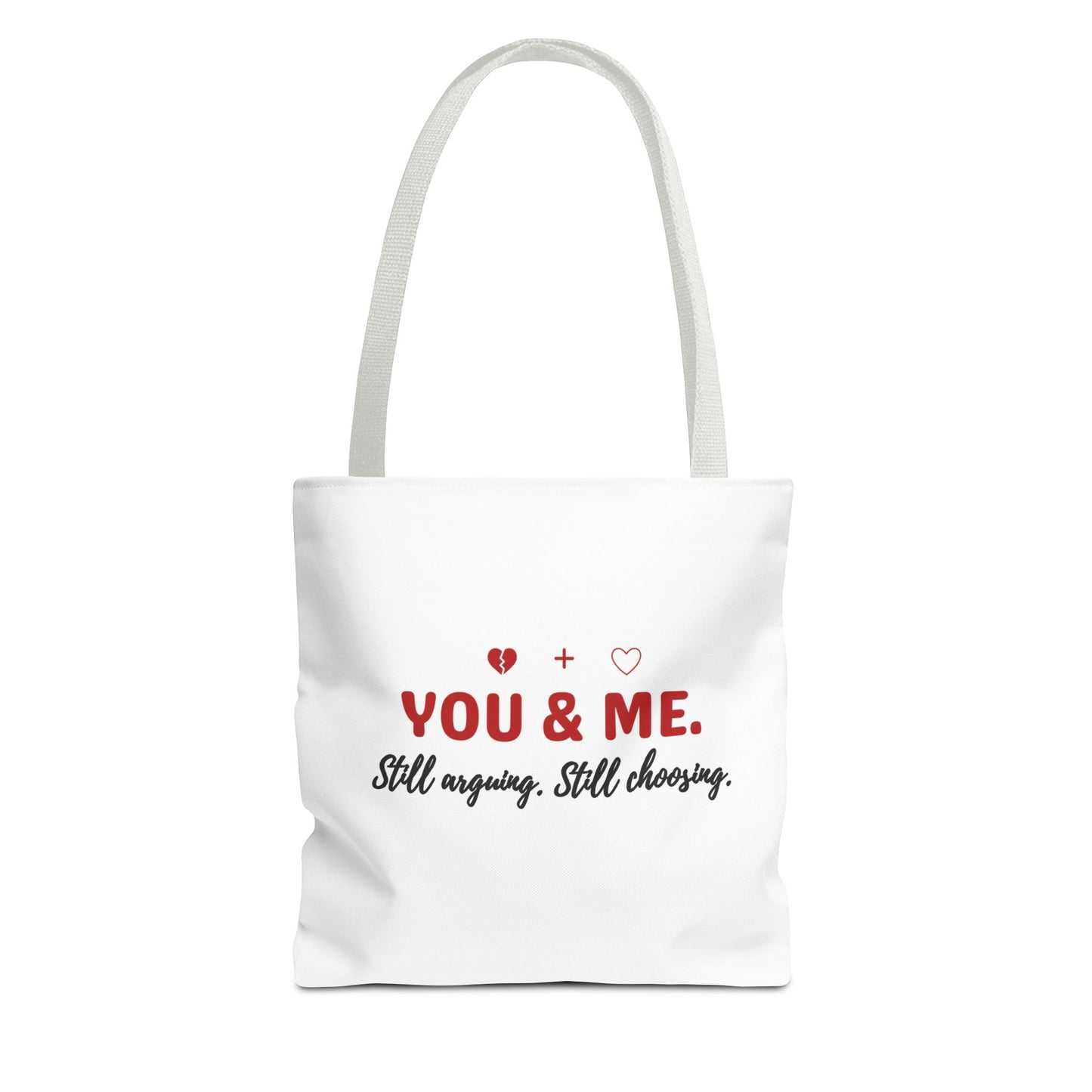 White tote bag with white handle and text 'YOU & ME. Still arguing. Still choosing.' on a white background