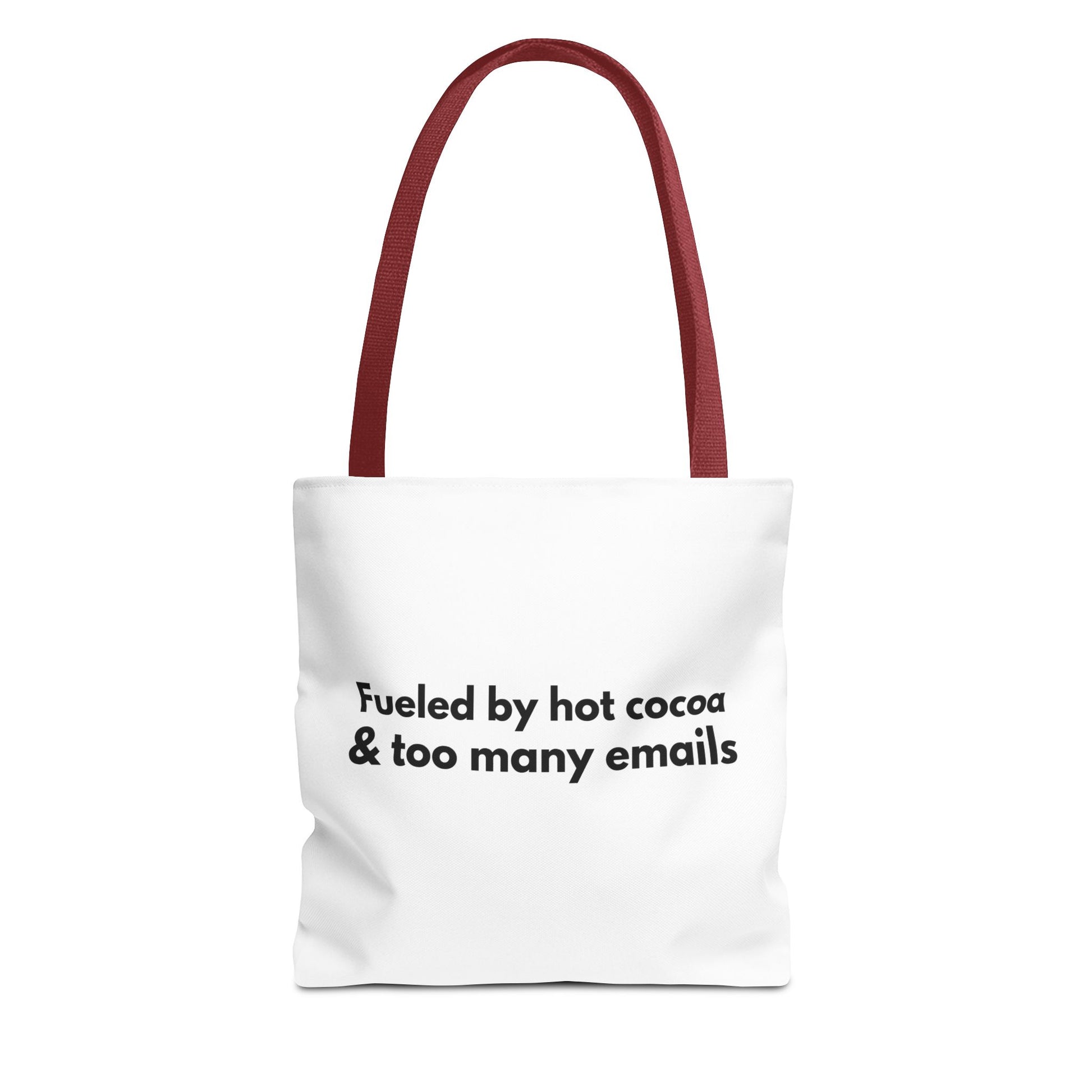 White tote bag with red handle and text 'Fueled by hot cocoa & too many emails' on a white background