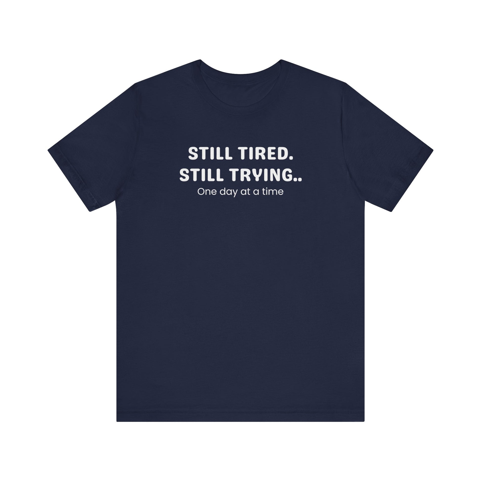 Navy t-shirt with white text 'Still Tired. Still Trying. One day at a time' on a white background