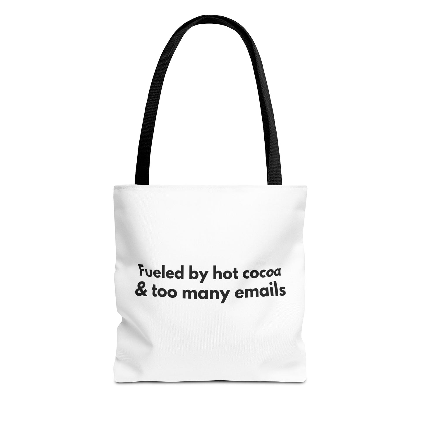 White tote bag with black handle and text 'Fueled by hot cocoa & too many emails' on a white background