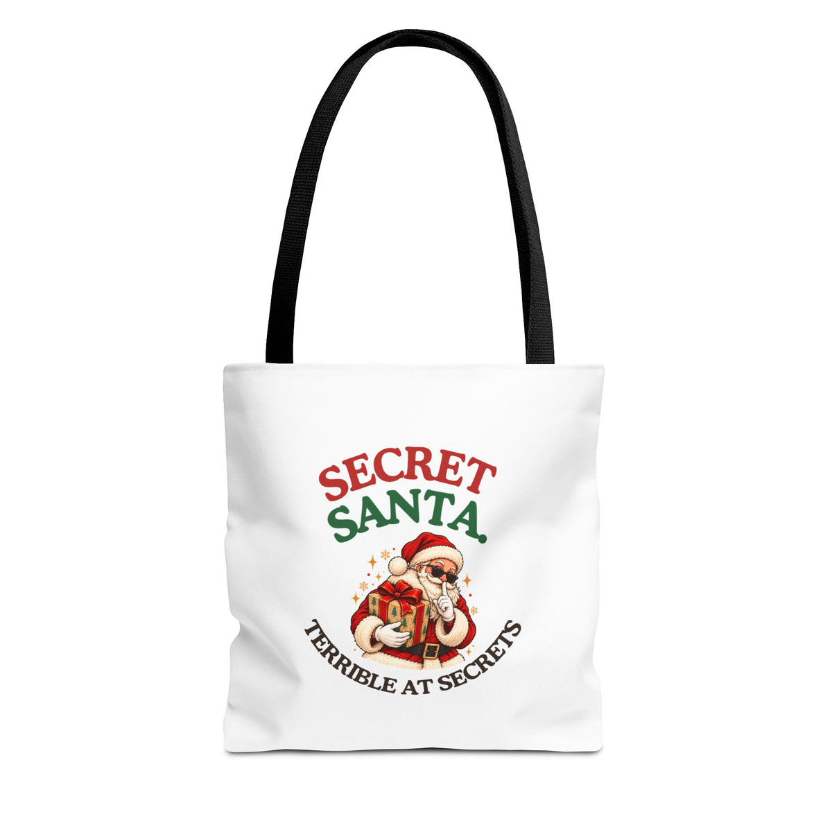A white tote bag with black handles featuring the “Secret Santa. Terrible at Secrets.” design on a white background