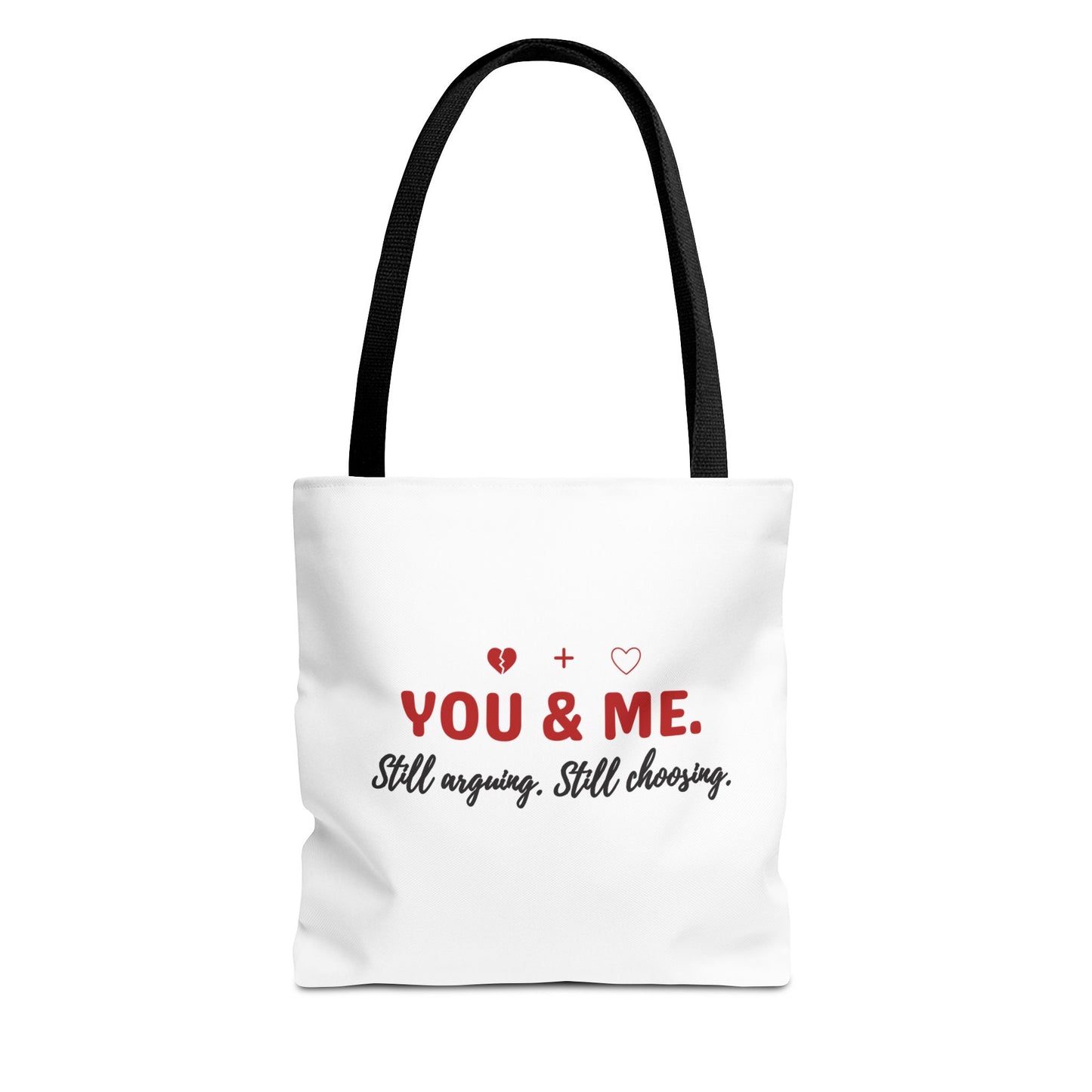 White tote bag with black handle and text 'YOU & ME. Still arguing. Still choosing.' on a white background