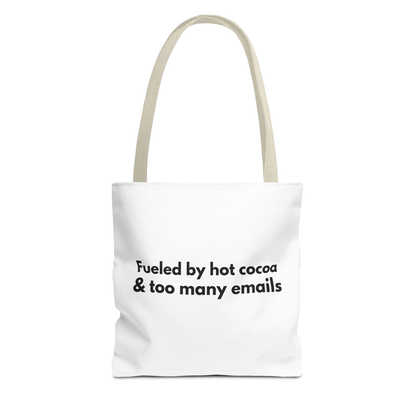 White tote bag with beige handle and text 'Fueled by hot cocoa & too many emails' on a white background