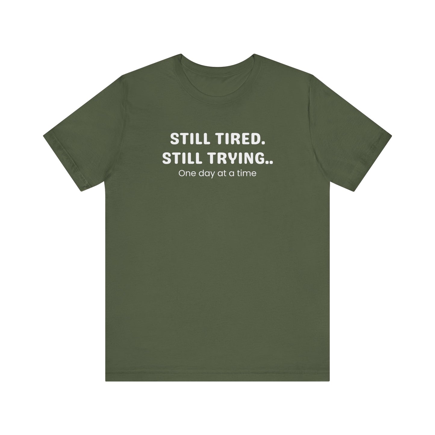 Green t-shirt with white text 'Still Tired. Still Trying. One day at a time' on a white background
