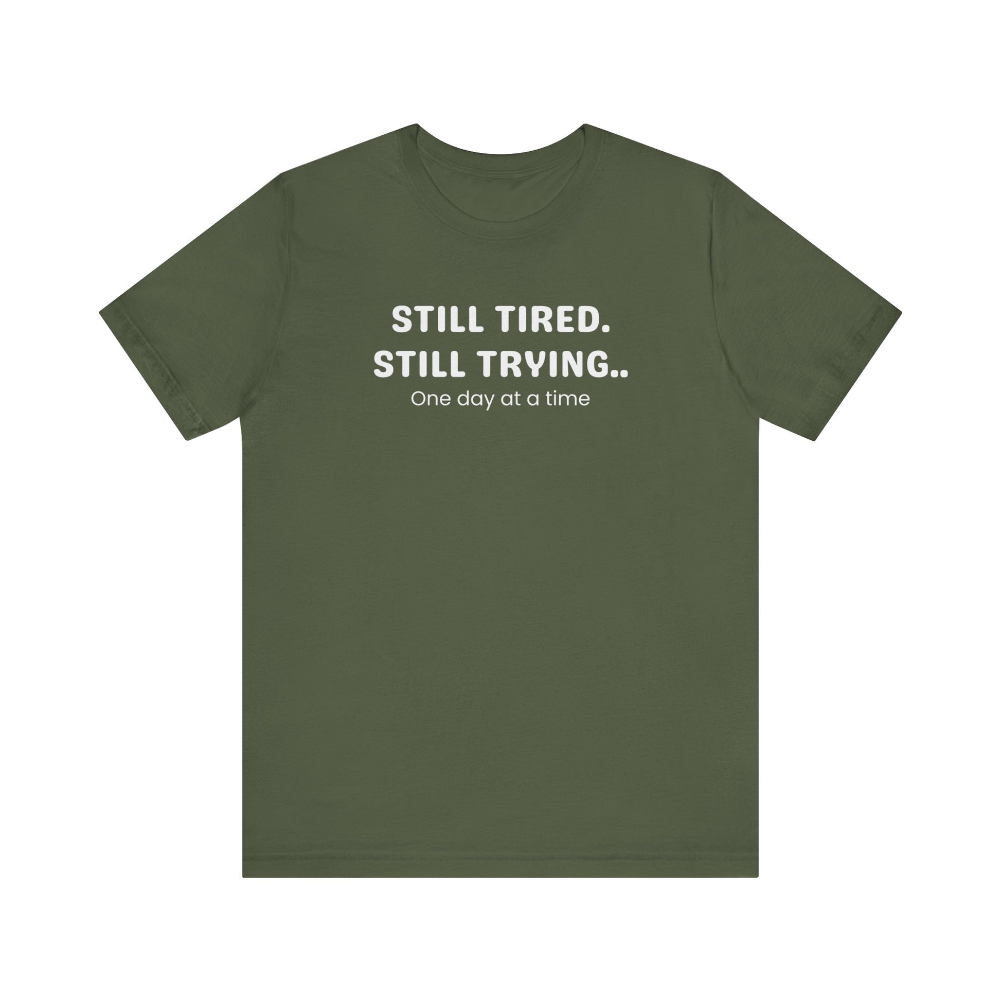 Green t-shirt with white text 'Still Tired. Still Trying. One day at a time' on a white background