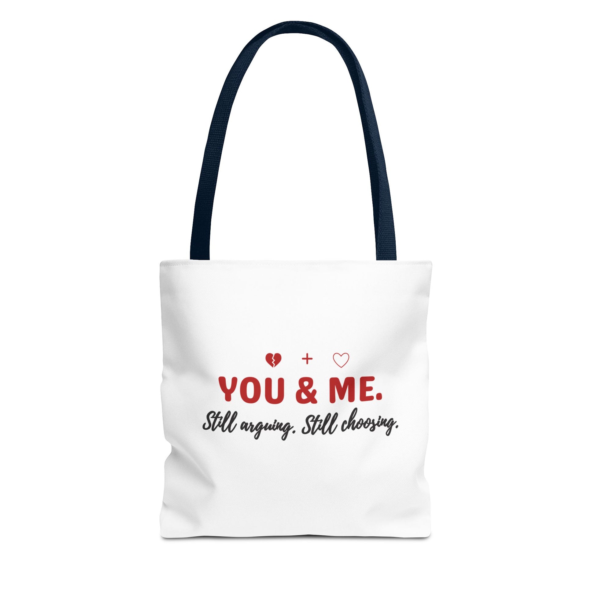 White tote bag with navy handle and text 'YOU & ME. Still arguing. Still choosing.' on a white background