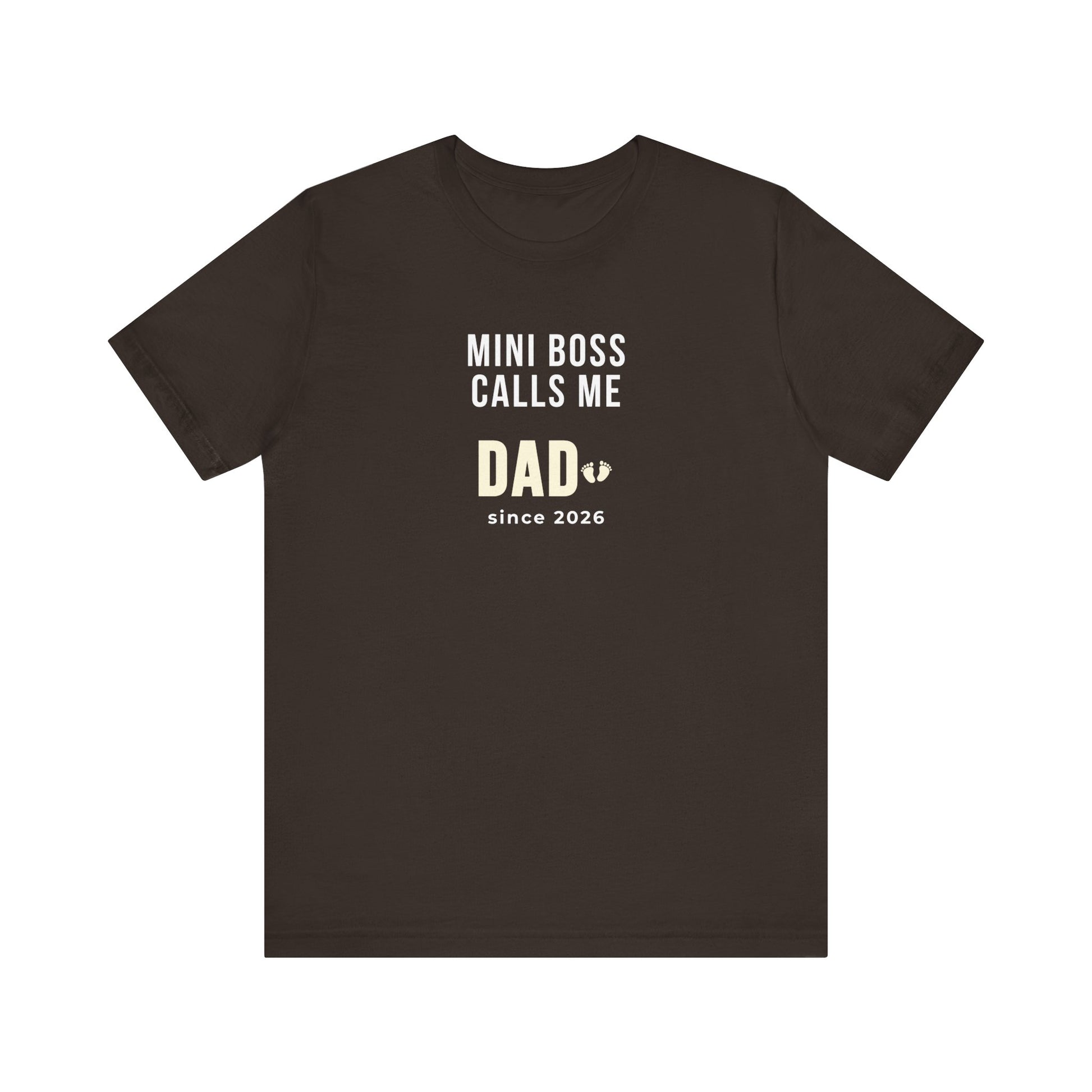 Brown t-shirt with white text 'Mini Boss Calls Me Dad – since 2026' on a white background
