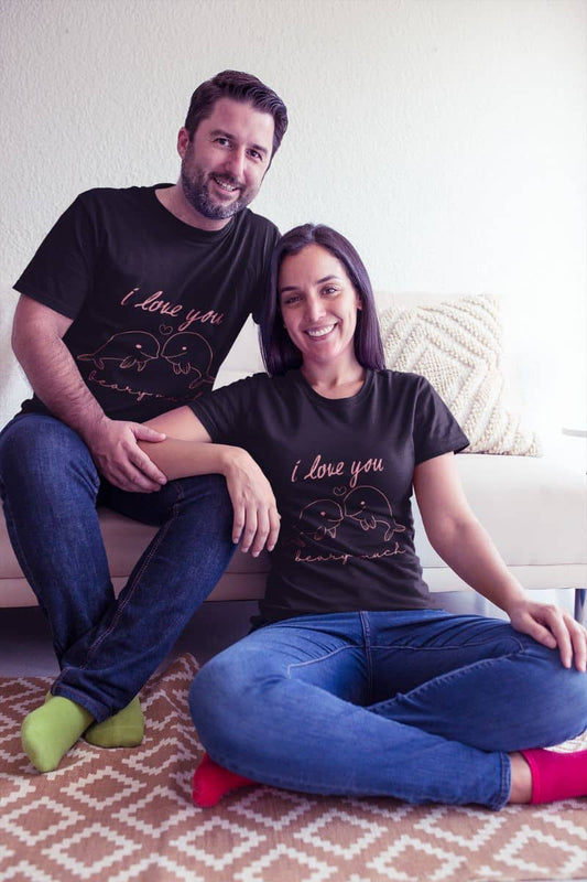 Adorable Dolphin love t-shirt with the couple smiling brightly and happily together in their love t-shirts, while he sits on the sofa and she sits on the floor with her arms resting on his lap