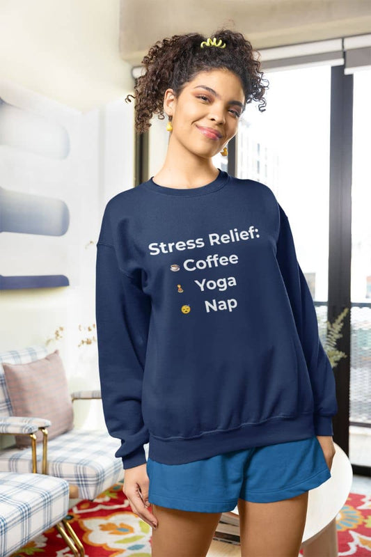 Anti-stress sweatshirt with a person wearing a navy blue sweatshirt with 'Stress Relief: Coffee Yoga Nap' text in a living room.