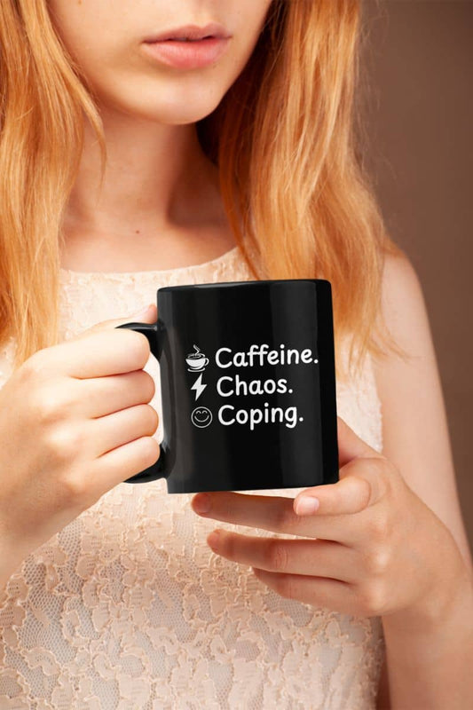 Anxious but caffeinated mug with a person holding a black mug with text 'Caffeine. Chaos. Coping.'